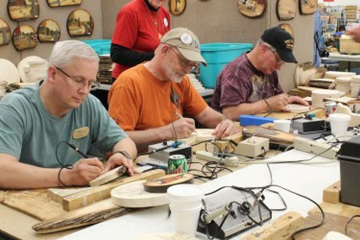 WOODCARVERS ROUNDUP: Members of the Grand Valley Wood Carvers out of Ionia partake in wood burning projects in one of many workshops going on simultaneously during the Evart Roundup, which will take place through Saturday. This is the 15th year of the event, which brings in hundreds from across the United States. (Pioneer photos/Karin Armbruster)