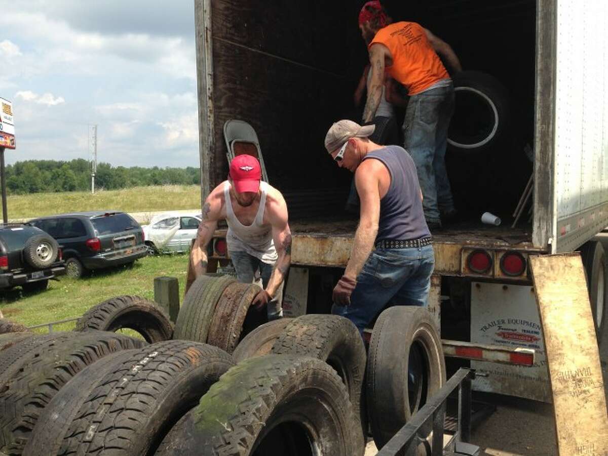 TIRE DISPOSAL: Four inmates from the Osceola County Jail helped residents load their unwanted tires onto the semitrucks during the third annual tire round-up which took place on dates in June and July. (Herald Review photo/Randy Johnston)