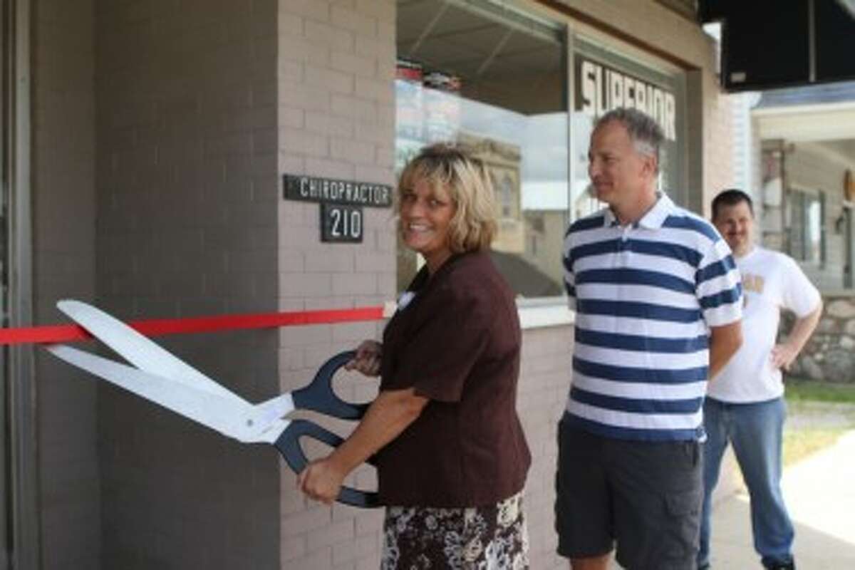 NEW START: Tracy Burgess prepares to officially open her business, Superior Touch Home Care, by cutting a ribbon on Wednesday, June 26. The business offers in-home, non-medical care such as house cleaning, meal preparation, transportation and more. (Herald Review photo/Emily Grove-Davis)