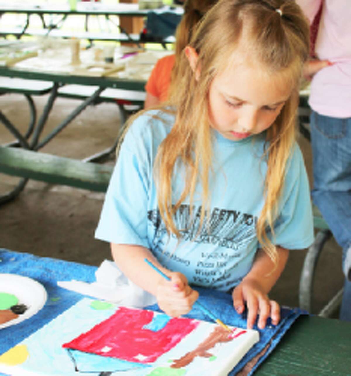 perfecting her art: Lauren McCarver, 7, has become quite a regular at Art in the Park. She enjoyed painting her family home. (Herald Review/Shannon Hartley)