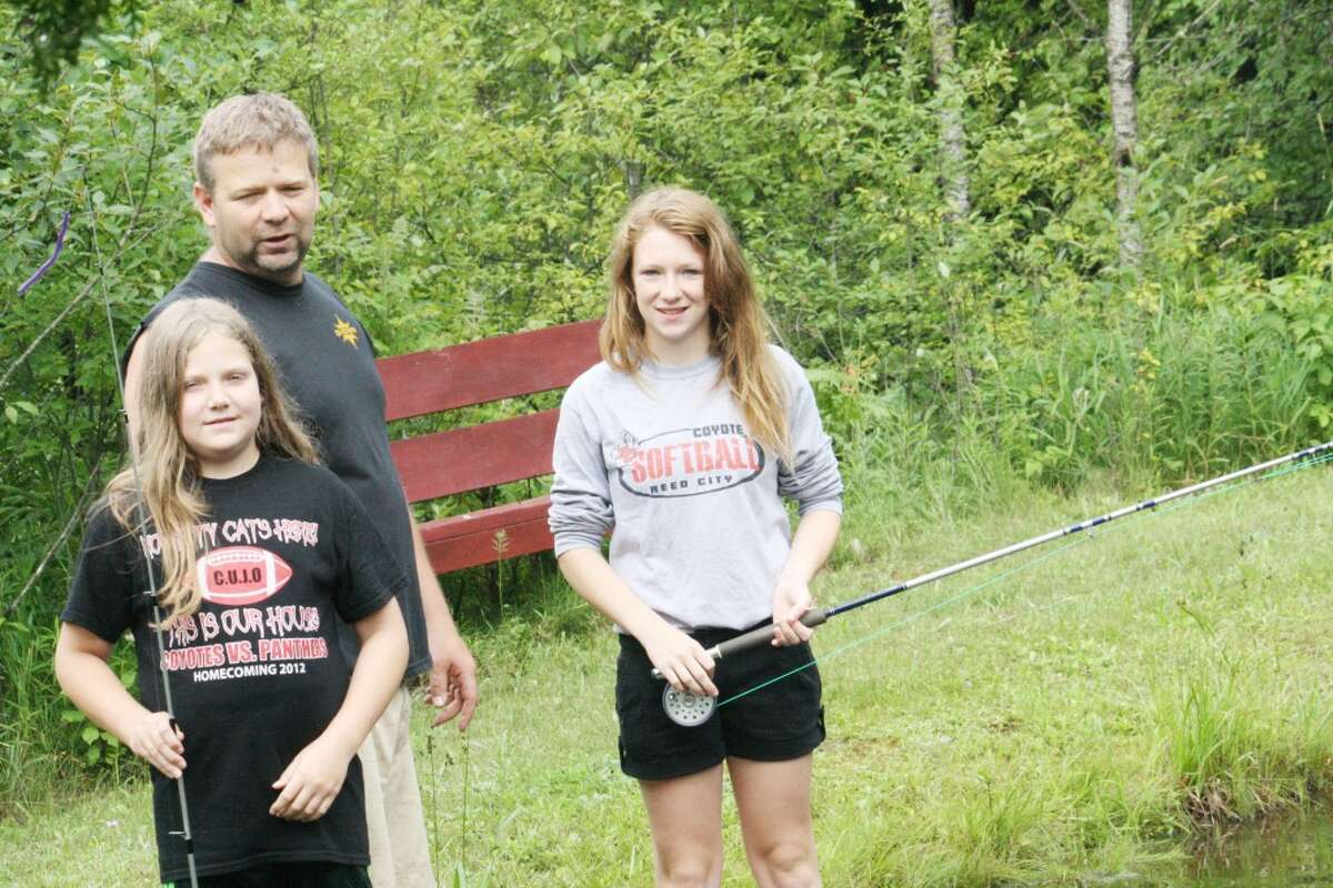 TIme to fish: Jeremy Andres and his two daughters, Lily, left and Ashley, get ready for an evening of fishing at their pond outside of their rural Ashton home. (Herald Review/John Raffel)