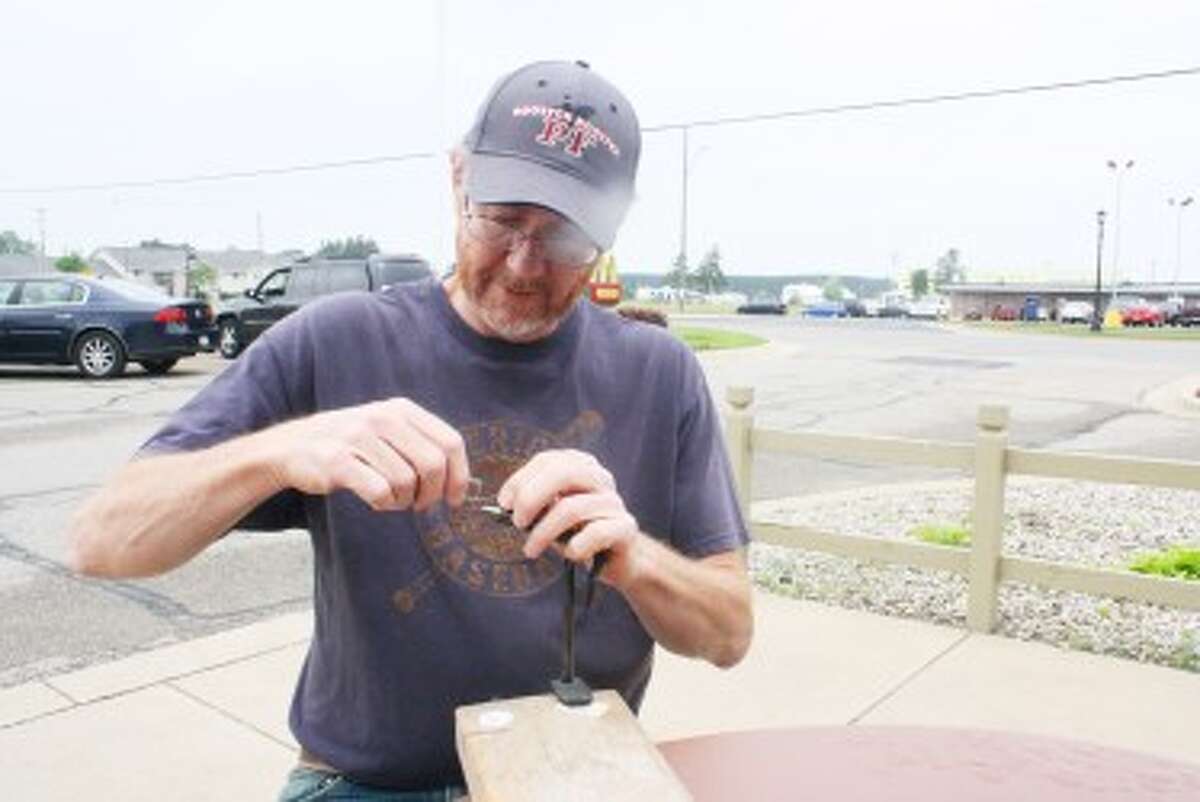 FLY FISHING: Evart’s Andy Duffy ties a fly to get ready for more fishing. (Herald Review/John Raffel)