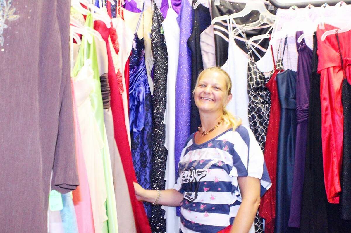 A POSITIVE PRESENCE: Unique 4 U owner, Rachel Strobel, stands next to the formal dresses she has in her store, located at 226 N. Main St. in Evart. The second-hand clothing store opened almost three months ago. Strobel said she wants her to be involved in the community and give back.(Herald Review photo/Emily Grove-Davis)