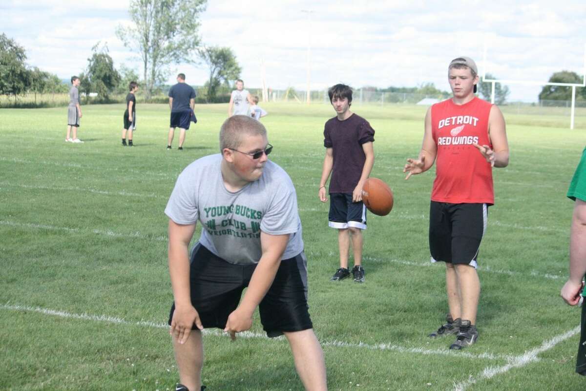 Football practice: Pine River's Brady Loop (from) and Josh Jackson, both sophomores, work on their snap exchanges Monday during the Bucks football camp.