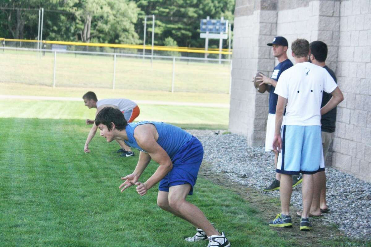 summer practice: Evart football players and coaches work on pass routes Monday morning. (Herald Review/John Raffel photo)