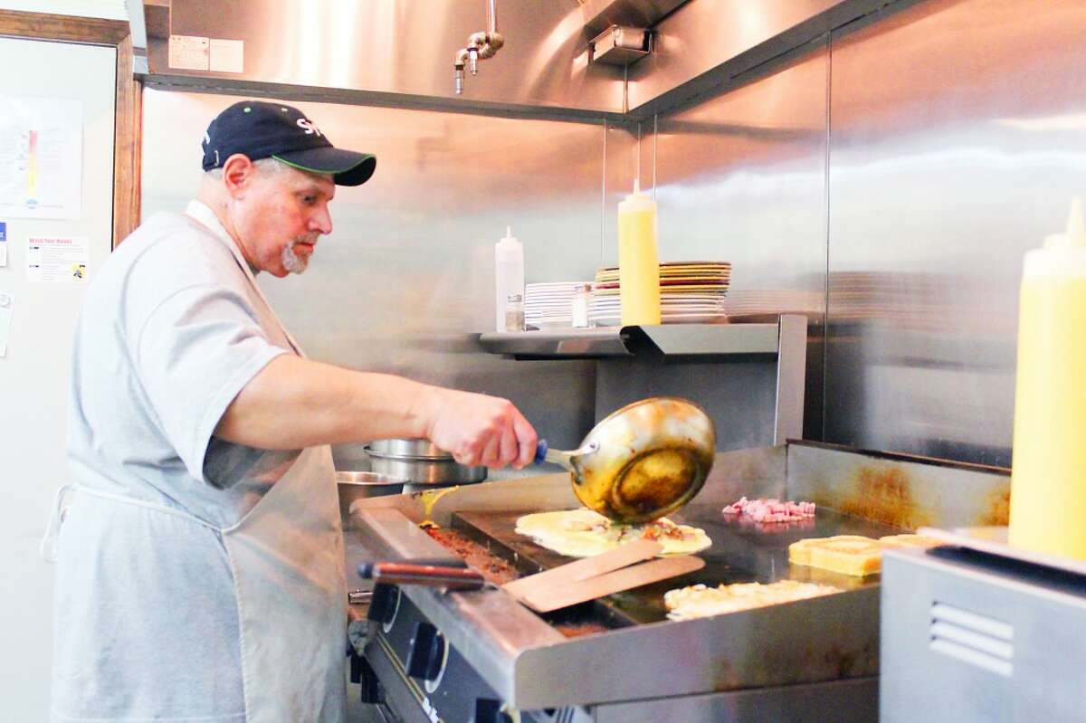 Omelet: Richard Pemberton, one of the owners of All American Cafe in Evart, prepares the 'Kitchen Sink' omelet on a flat-top grill. Pemberton and co-owner Shari Holben expanded their restaurant business from Nestle Inn Cafe in Reed City. (Herald Review photo/Karin Armbruster)
