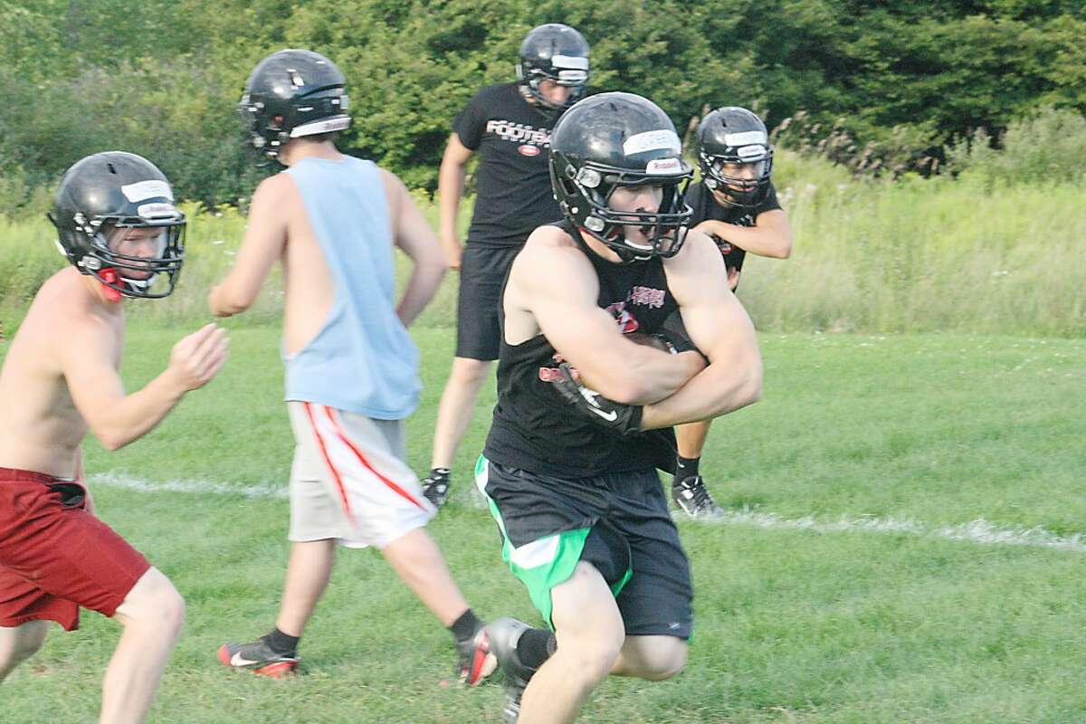 RUNNING DRILLS: Jon Green of Reed City takes the football during a drill Monday night. (Herald Review/John Raffel)