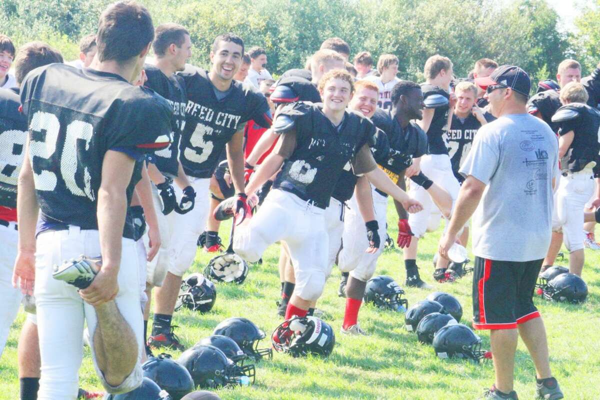 Reed City football players share a few laughs prior to practice but it's all business moments later during Monday workouts. (Herald Review/John Raffel)