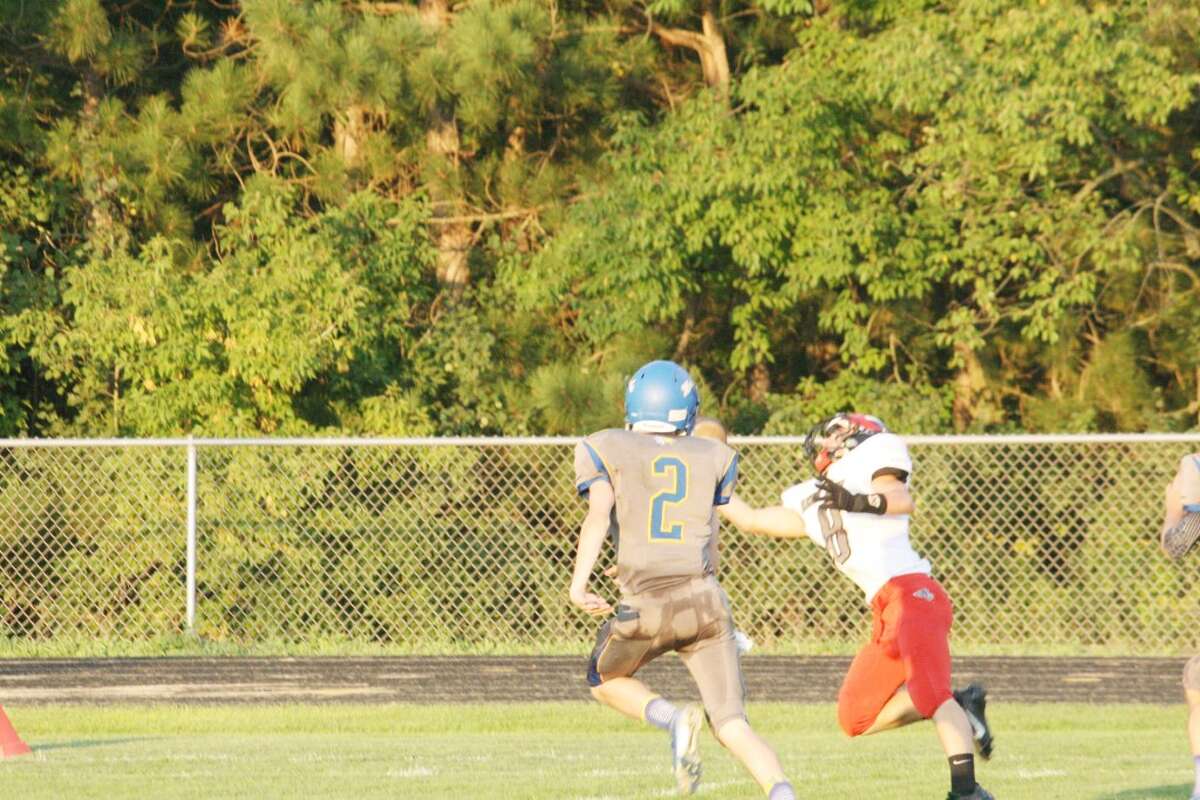 Josh Saez of Reed City is about to make a circus grab of a fourth-down pass from quarterback Chad Samuels during Friday's win at Morley Stanwood. (Herald Review/John Raffel)