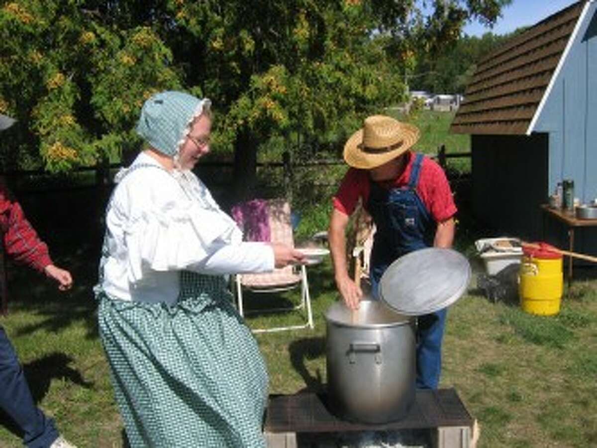 STEW: Christopher Clark Day was celebrated in Marion on Saturday with a hearty lumberjack stew. Ingredients include ham, carrots, cabbage, onions, potatoes and turnips. Here, Bernard Prielipp serves the dish to Jerry McAlary. (Herald Review photo/Randy Johnston)