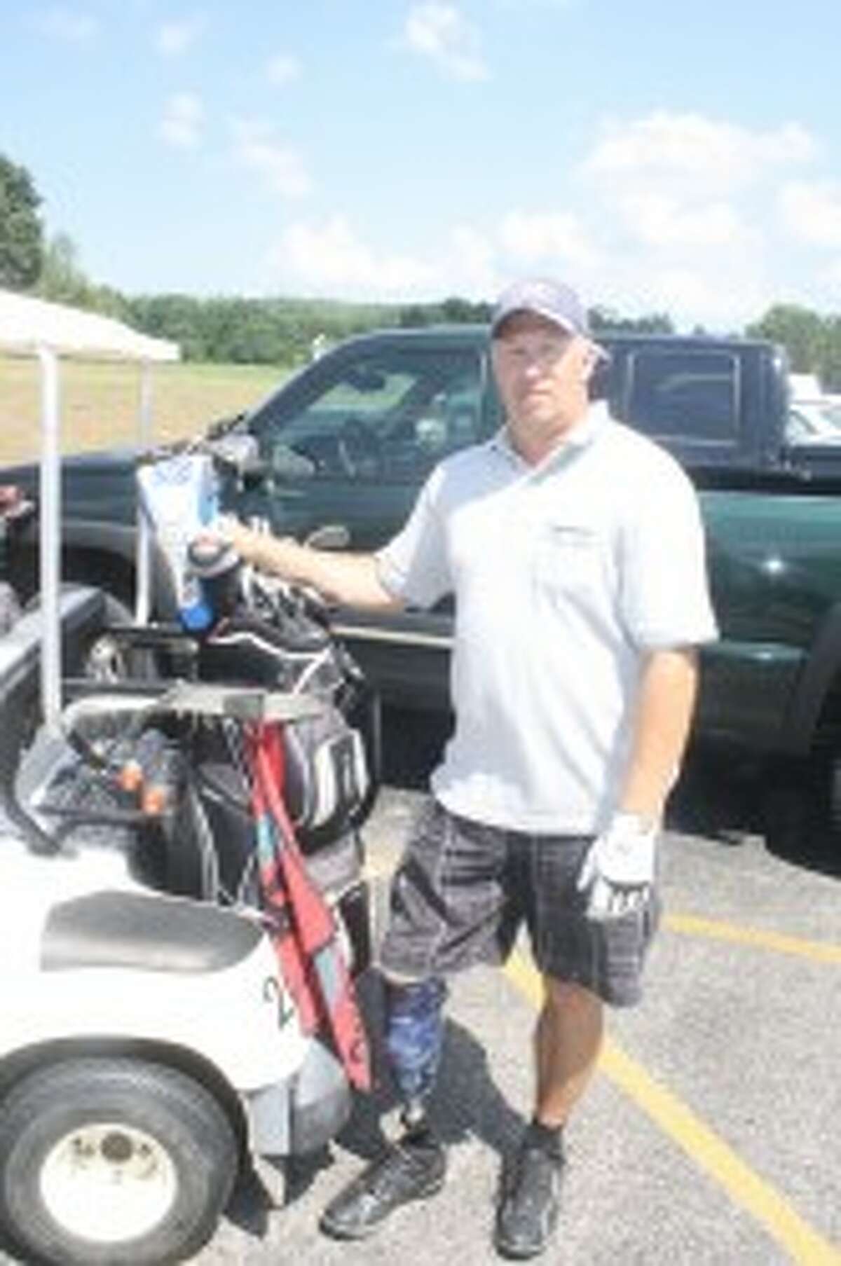 READY TO GOLF: Jeff Smith of Evart, a Big Rapids postal worker who is an amputee on his right leg, below the knee, gets ready for a round of golf recently at Spring Valley Golf Course in Reed City. (Pioneer photo/John Raffel)