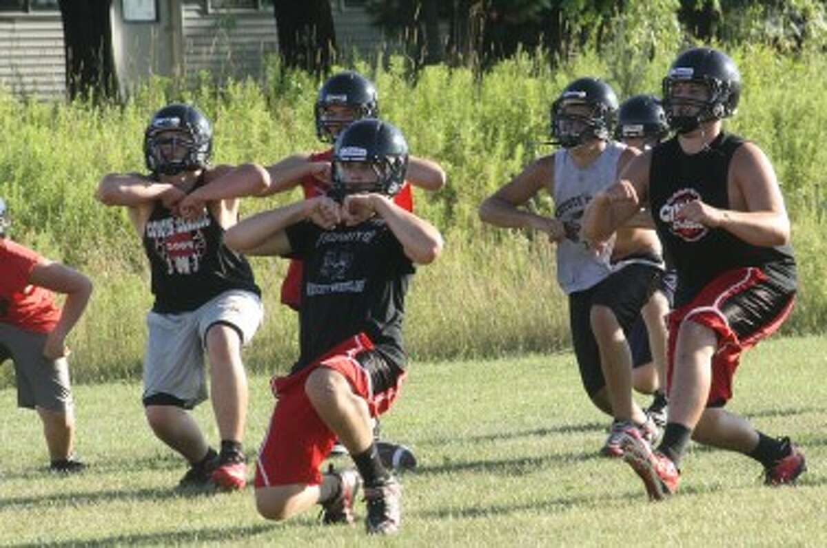 THROUGH THE MOTIONS: Reed City football players work on drills at last week's football camp. (Pioneer photo/John Raffel)