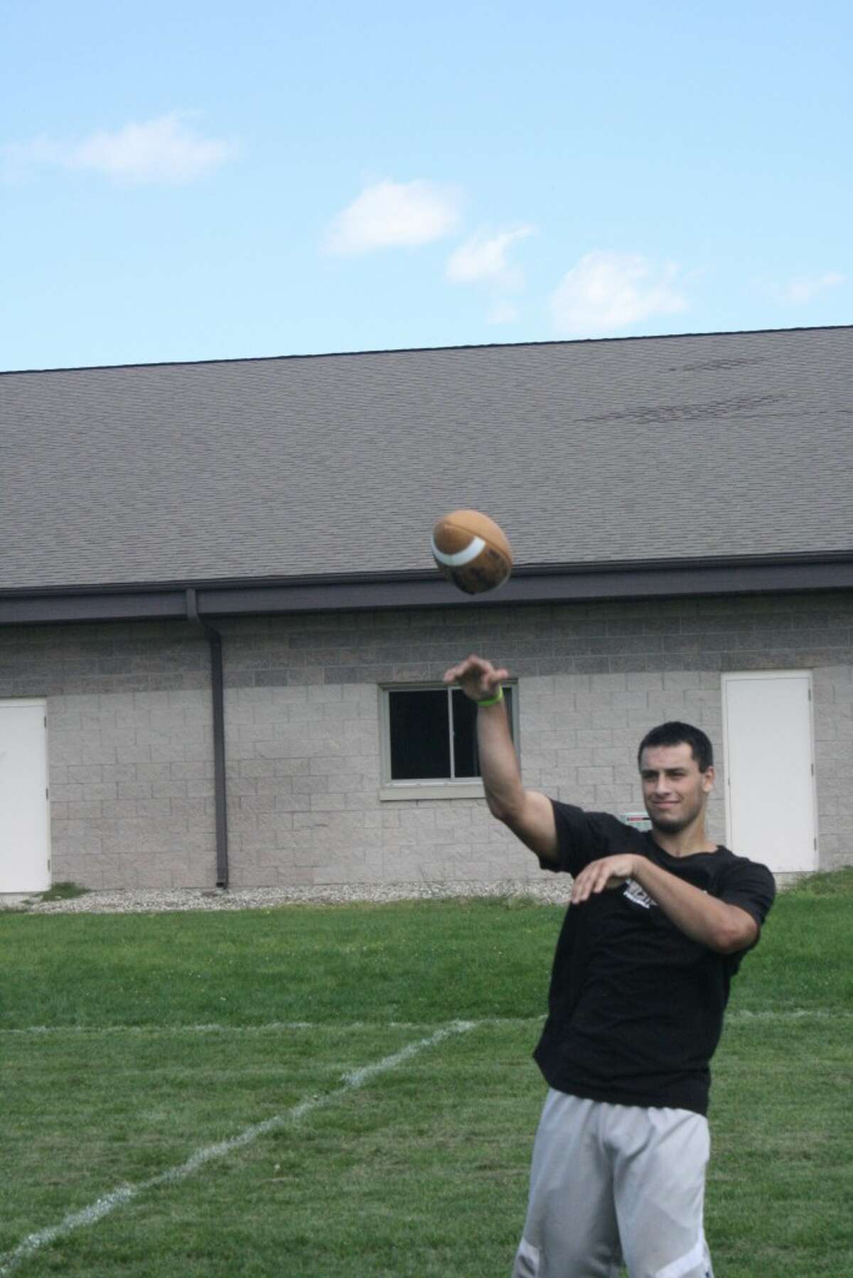 Austin Grein warms up his arm during an Evart football practice (Herald Review photo/John Raffel)
