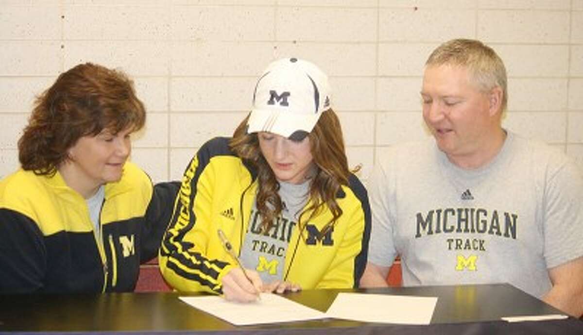 SIGNING ON: Sami Michell (center) signs her letter of intent to run track at the University of Michigan. (Pioneer photo/John Raffel)