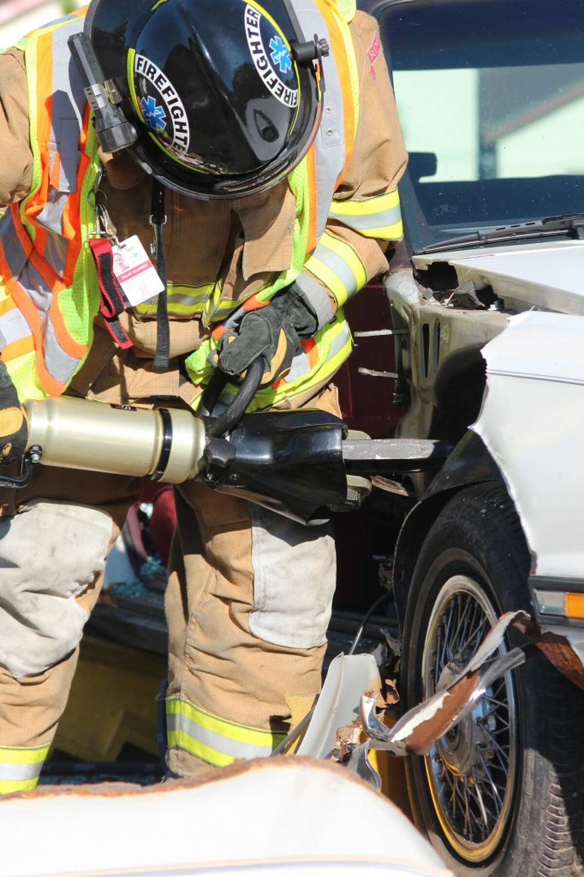 CLEAN CUT: Firefighters from the Reed City Fire Department uses a new hydraulic rescue tool to cut through a donated demo car during a practice exercise Tuesday. The new tools were purchased with a $16,000 AAA grant. (Herald Review photo/Sarah Neubecker)