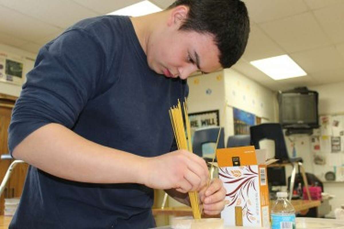 MORE THAN NOODLES: Paul Gaffney plans to use spaghetti noodles and hot glue to create a rod to hold together part of the Falkirk Wheel bridge replica. Gaffney is a member of the “Pasta PACCK” from Evart High School competing in Ferris State University’s 14th Annual Spaghetti Bridge Competition this weekend. (Pioneer photos/Lauren Gentile)