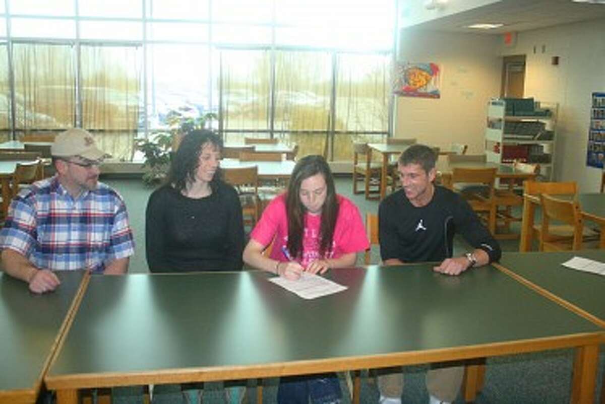 SIGNING ON: Attending the signing ceremonies for Erica Buchner last week at Pine River were, at left, her parents, David and Serena Crawford, and at right, Ty McGregor, coach at Kirtland Community College. (Herald Review/John Raffel)