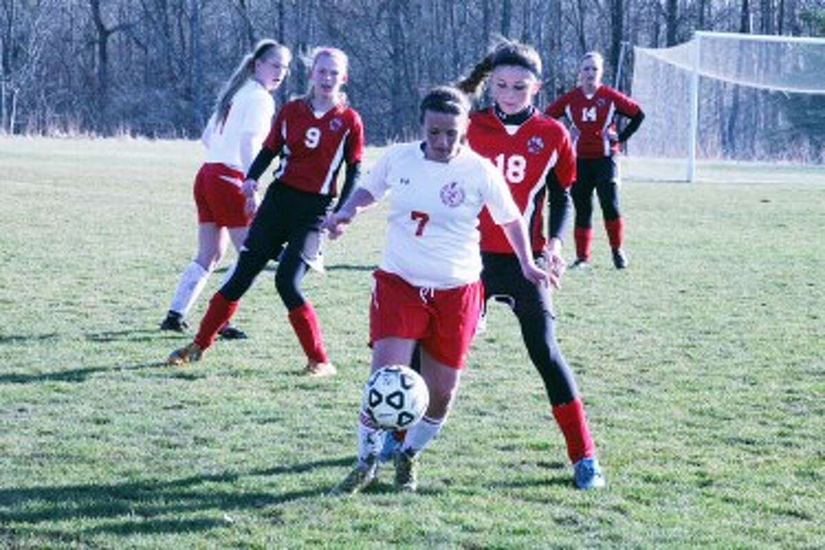 GETTING AFTER IT: Big Rapids' Paige Johnson (7) looks to shield off Reed City's Alaina Woodard (18) during Wednesday's soccer action. (Pioneer photos/Martin Slagter)