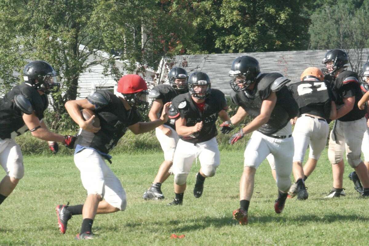 RUNNING STRONG: Reed City football players work on a running play during a Monday practice. (Herald Review photo/John Raffel)