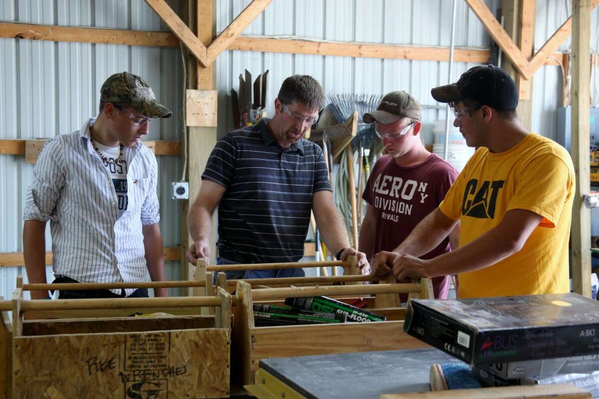 DIVERSE SKILL SET: Integrated Construction Technology instructor Chris Battle directs students in setting up their construction lab on Wednesday. Battle enjoys teaching construction trade courses because of the variety of skills covered.