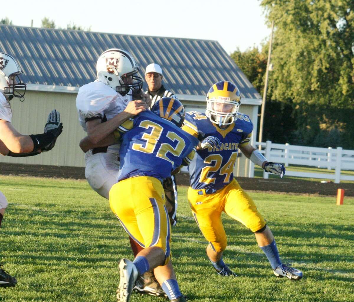 WRAPPED UP: Evart's Austin Grein (32) wraps up a Marion ball carrier during Friday's football contest at Evart High School. (Herald Review photo/John Raffel)