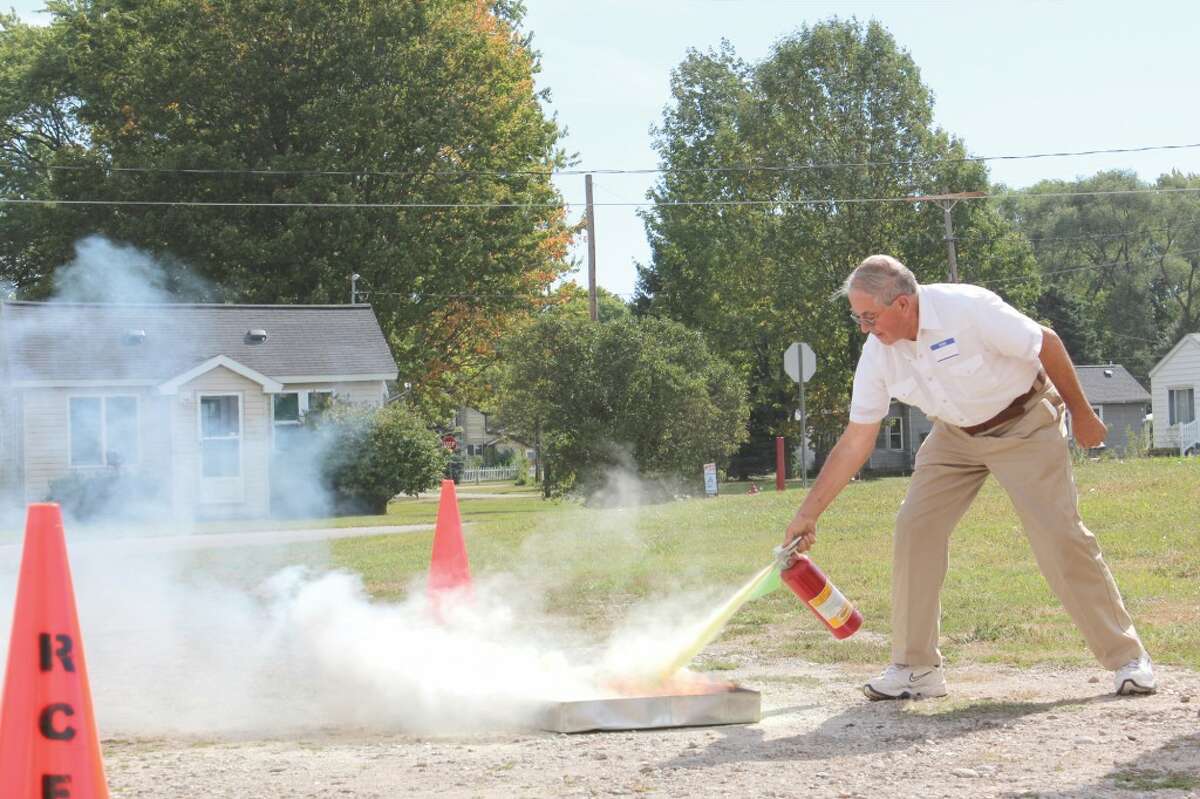 FIRE SAFETY: Frank Gondek, 77, puts out a fire during a demonstration at Camp 9-1-1. Senior citizens learned how to best prepare for and react in emergencies among other important information during the educational day. (Herald Review photo/Sarah Neubecker)