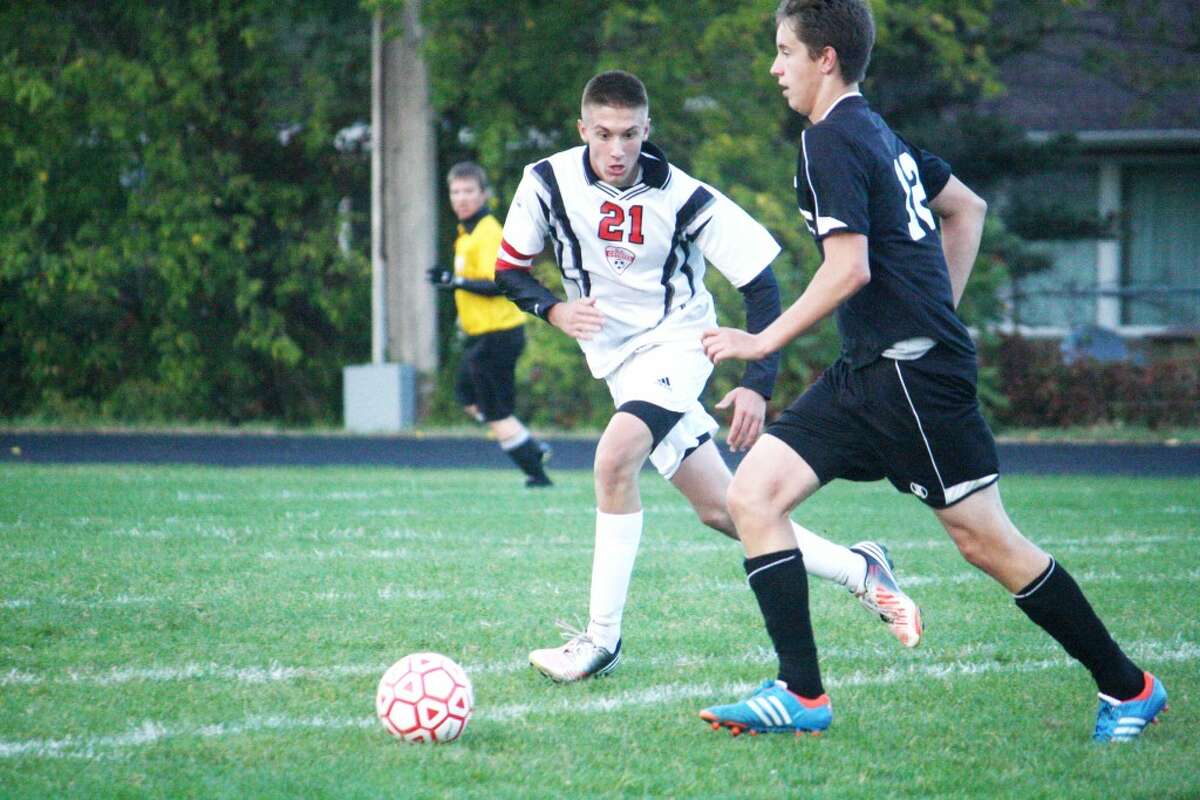 PLAYING D: Reed City’s Trevor Nelson closes in on a Newaygo player during Tuesday’s boys soccer match at Reed City. (Herald Review photo/John Raffel)