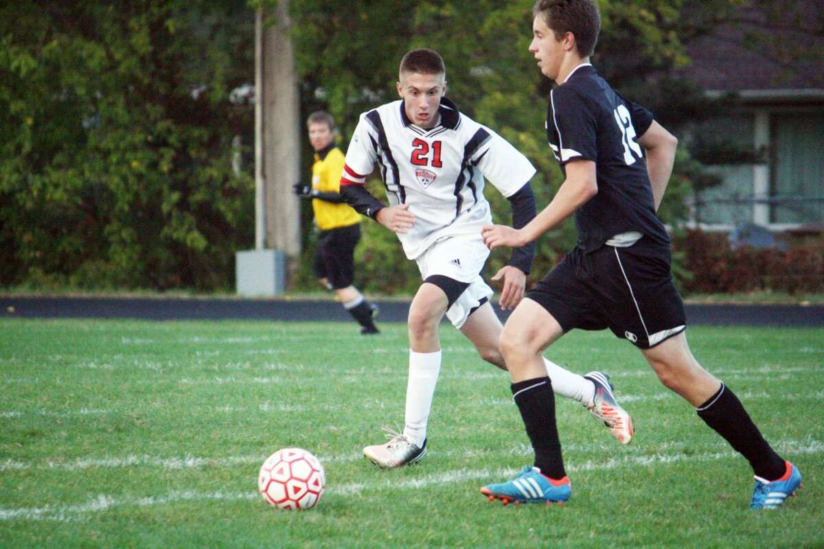 GOING FOR THE STEAL: Reed City's Trevor Nelson (21) goes after the ball against Newaygo last week. (Herald Review photo/John Raffel)