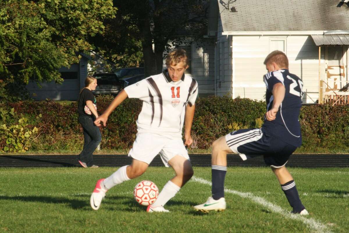FOOTWORK: Reed City's Quinten Kichak (11) concentrates on the ball as he tries to pass a Lakeview defender during Tuesday's high school soccer action at Reed City High School. (Herald Review photo/John Raffel)