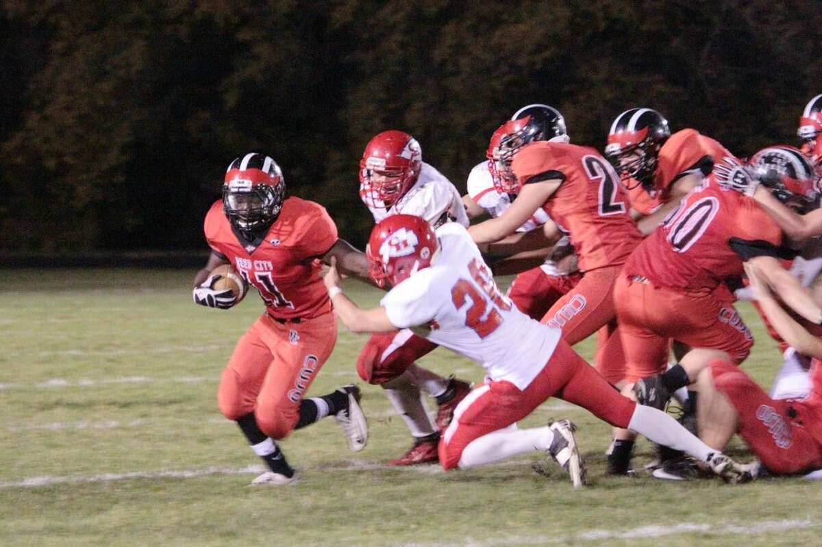 PRESSING FORWARD: Reed City's Paris Jones (11) tries to escape from the Chippewa Hills defense. (Herald Review photos/Justin McKee)
