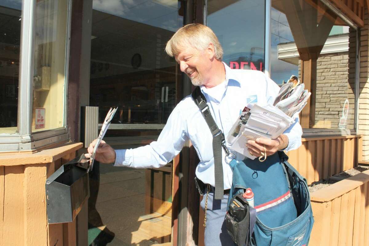MAIL TIME: Long-time mail carrier Bill Rogers makes a delivery to Pompeiis Pizza in downtown Reed City. Rogers said if he wasn't he the mail business, he would like to be a farmer. (Herald Review photo/Sarah Neubecker)