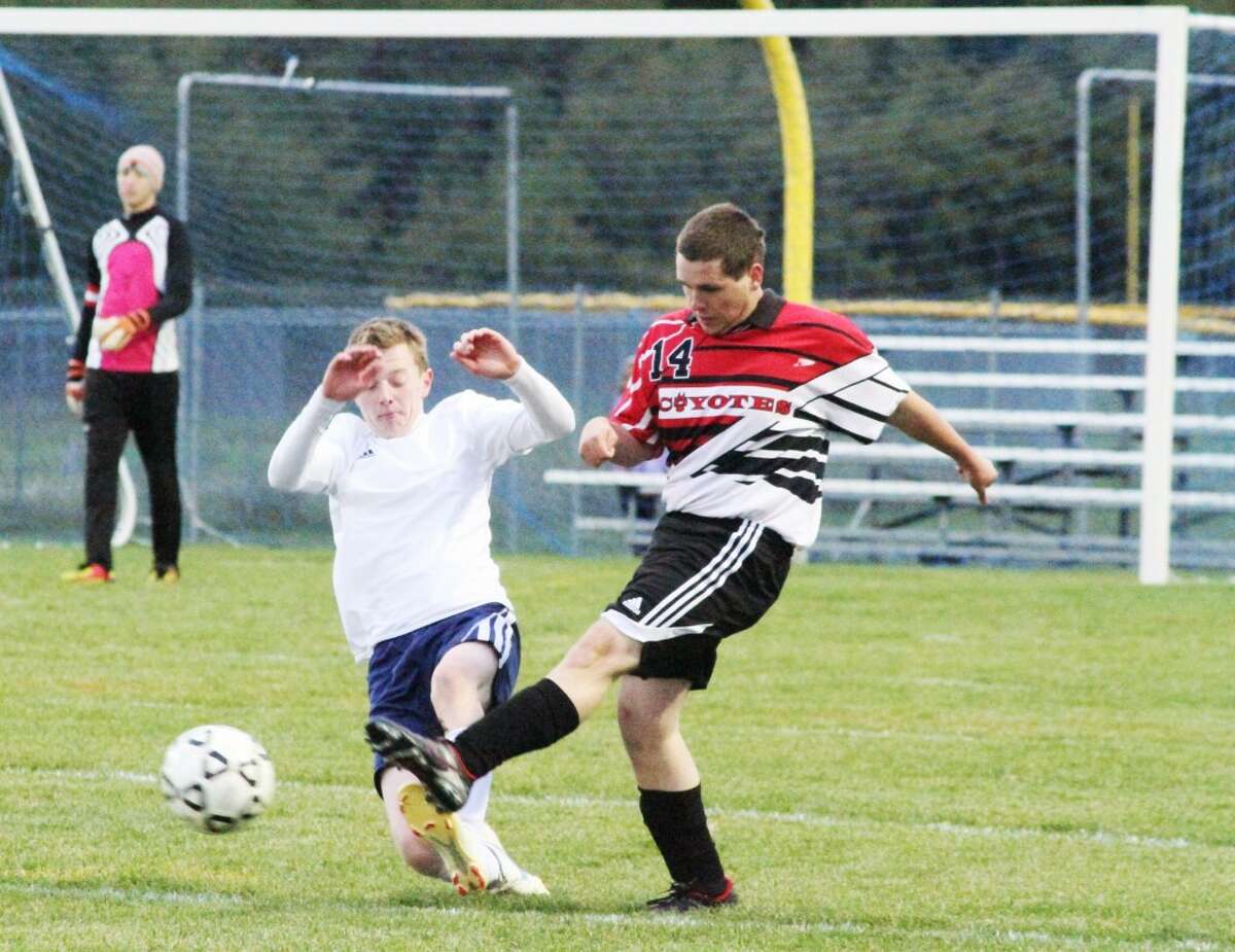 BOOTED: Reed City's Seth Poirot (14) kicks the ball away from a Manistee player during Monday's boys soccer contest. (Pioner News Network photo/Dylan Savela)