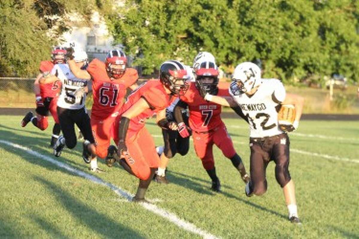 ON THE CUSP OF PERFECTION: Reed City defensive players including Eric Bradford (7) and Ian MacDonald (61) go after the ball carrier in action earlier this season. (File photo)