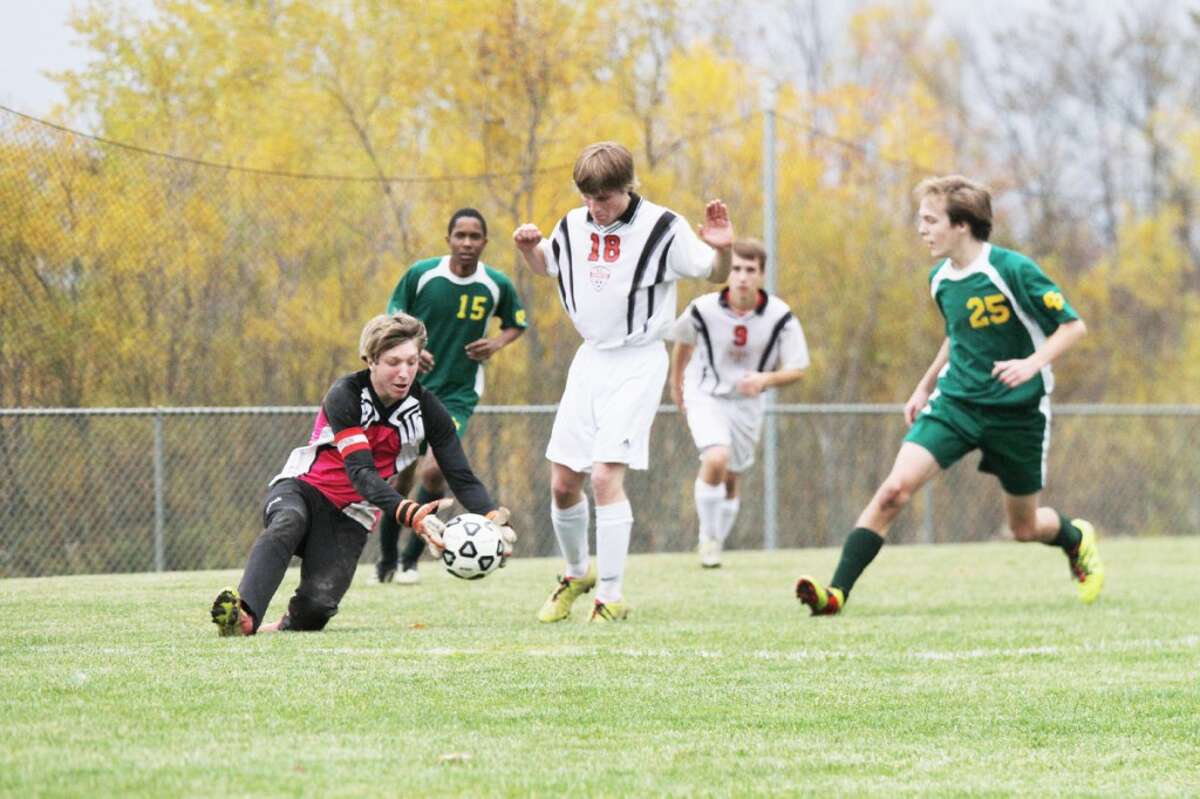 FIRST TO THE BALL: Reed City keeper Ben Schermerhorn (left) gets to the ball ahead of teammate Quinton Kichak (18) and a Comstock Park player during Wednesday's boys soccer match at Pine River High School. (Herald Review photo/Bob Allan)