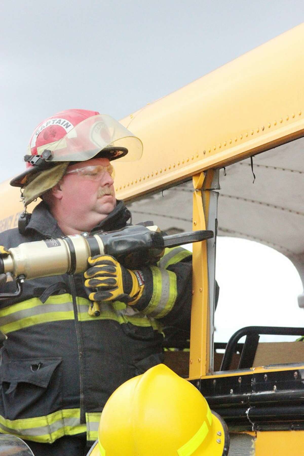 JAWS OF LIFE: Capt. Rick Ball, of the Lincoln Township Fire Department, uses the Jaws of Life to cut into a school bus during a bus extrication exercise on Saturday in Reed City. (Herald Review photos/Jonathan Eppley)