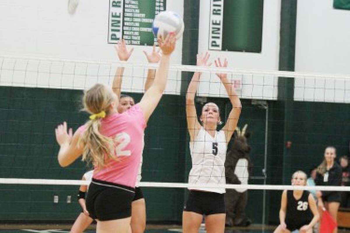 SOLID D: Miriah Holmes (left) and Jamie Justin (5) go up for the block in Pine River's home game with McBain last week. (Herald Review photo/Martin Slagter)