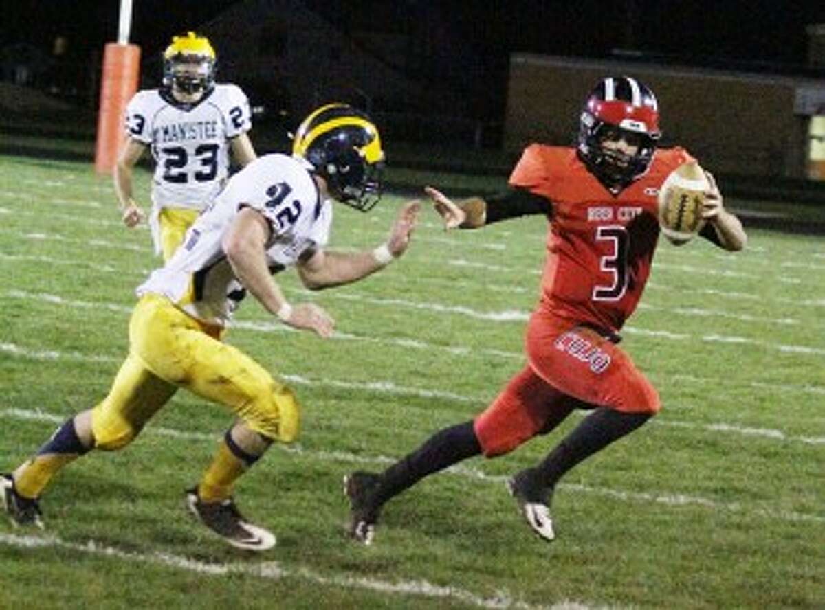 GET OUT OF MY WAY: Reed City quarterback Chad Samuels (3) picks up some yards before being tackled by Manistee's Lane Gancaraz during Friday football action. (Pioneer News Network photo/Matt Wenzel)
