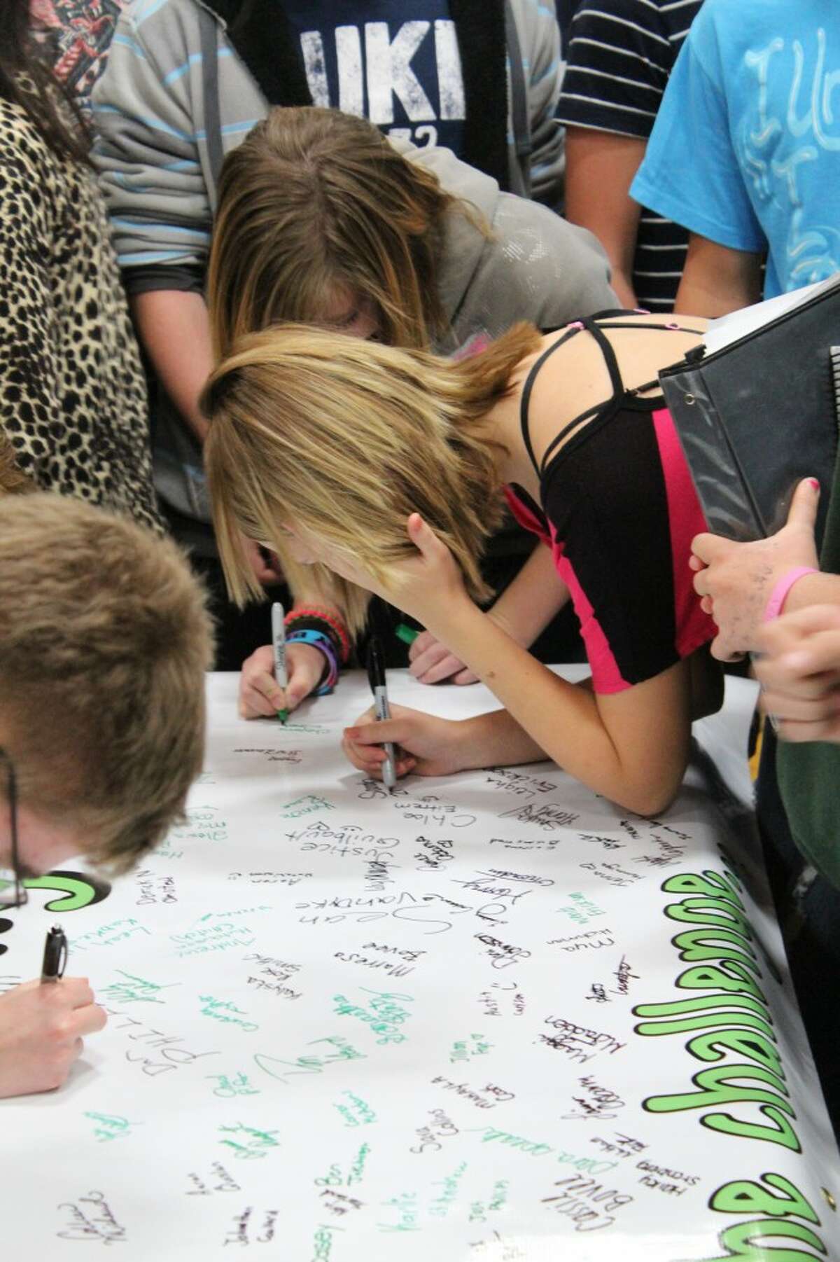 TAKING THE CHALLENGE: Pine River High School Students sign a banner saying they will take the Kids Driving Responsibly challenge in honor of Kelsey Dawn Raffele, who was killed in a car accident while talking on her cell phone.