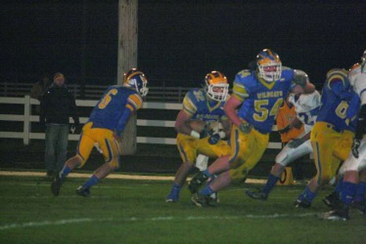 Robert Burge (54) looks to make a block downfield against Carson City-Crystal. (Herald Review photo/John Raffel)