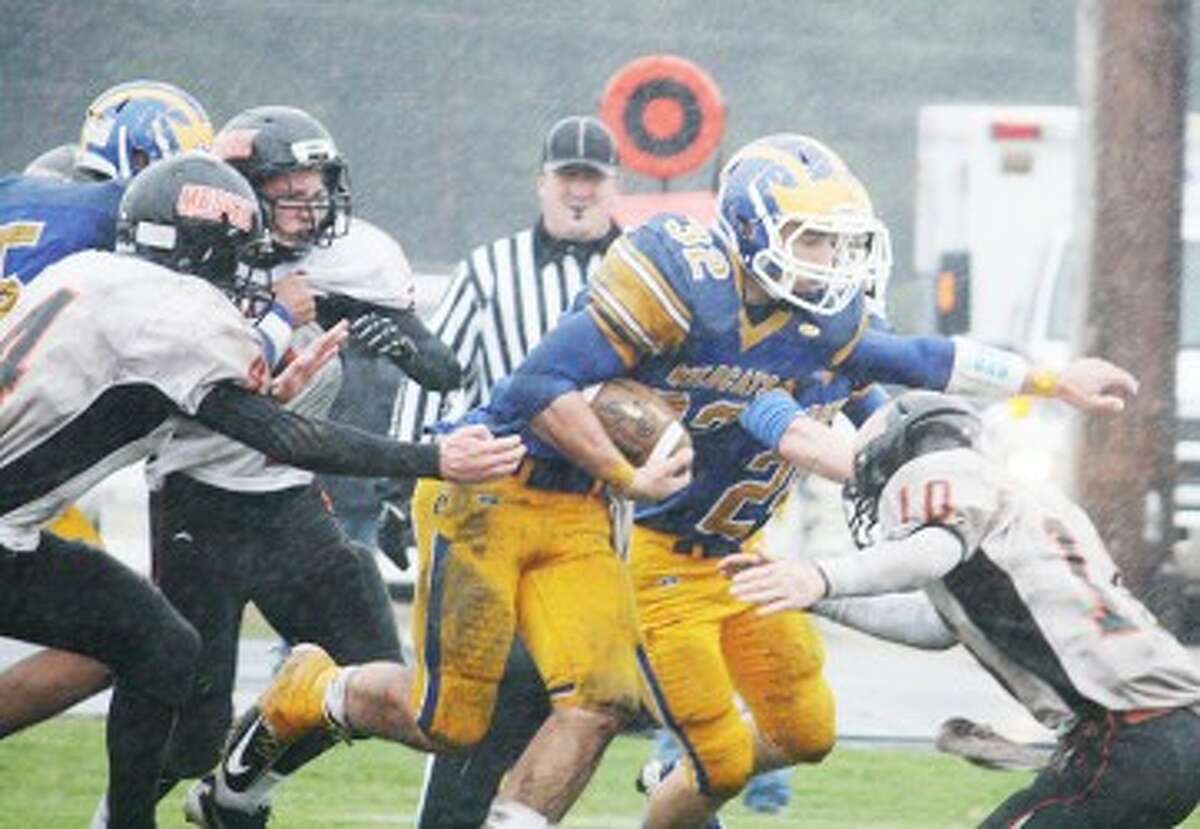 GRIND IT OUT: Evart running back Austin Grein (32) bursts through an opening during high school football action earlier this season. Grein and Evart will take on Lake City in second round action Friday. (Pioneer file photo)