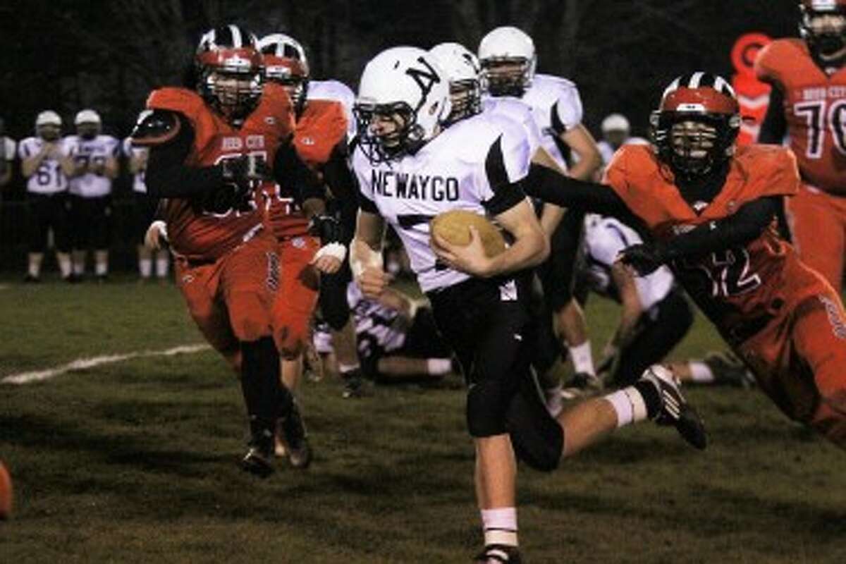 HE'S OFF: Newaygo's Weston Butler breaks a tackle by Reed City's Jake Vincent during Friday's district final at Reed City High School. (Pioneer photo/Bob Allan)