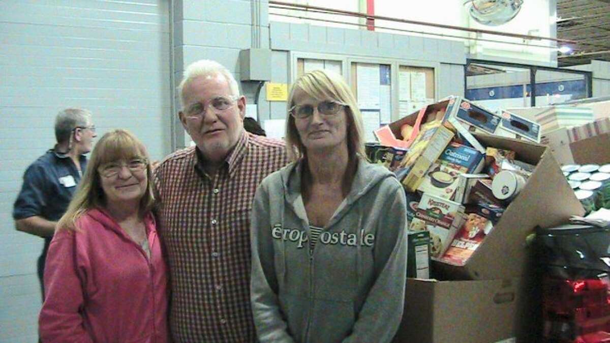 DONATION: Ventra employees Heidi Pontius (left) and Nancy Vokes pose with Sears Food Pantry Facilitator Ken Phillips (center) after revealing two pickup trucks stacked high with food. The members of the women's committee from UAW Local 2270 hosted a food drive for all Ventra employees over the course of two weeks. (Courtesy photo)