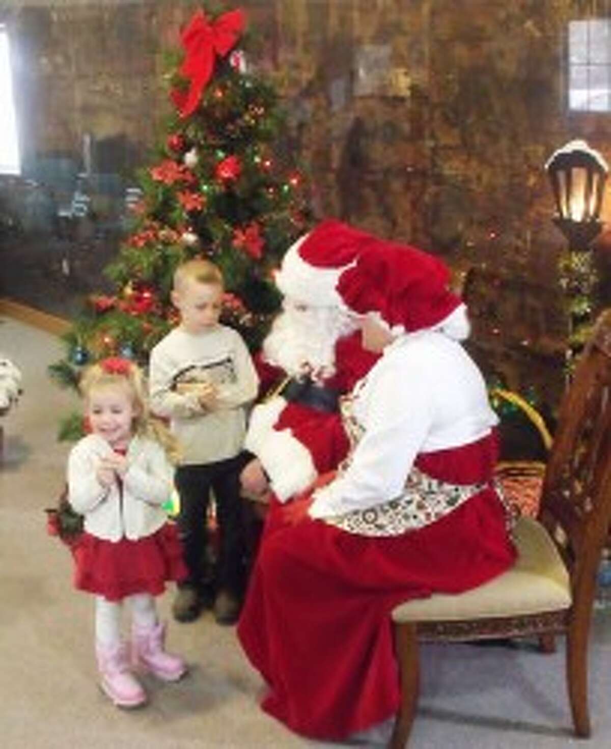 A LITTLE SHY: Hundreds of children waited in line to see Santa on Saturday during the annual Christmas in a Small Town in Evart.