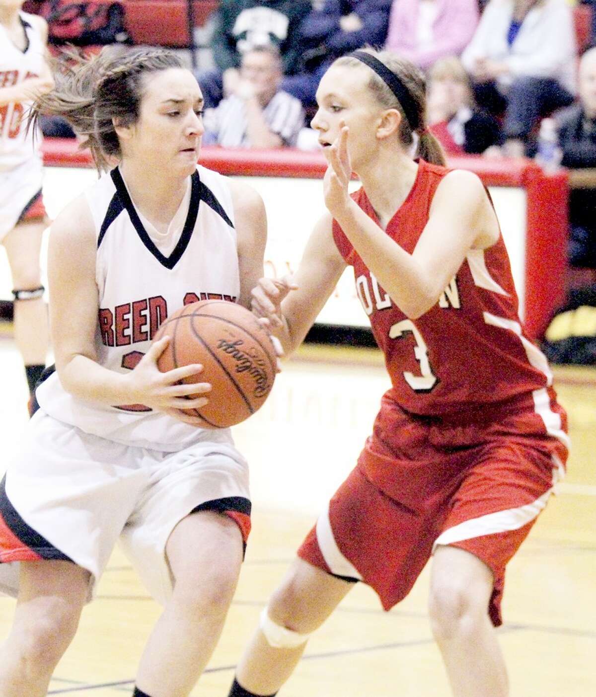 WORKING FOR A WIN: Reed City’s Alex Donley (left) tries to get past Holton’s Katie Wildfong during Friday’s girls basketball contest at Reed City High School. (Herald Review photo/Martin Slagter)