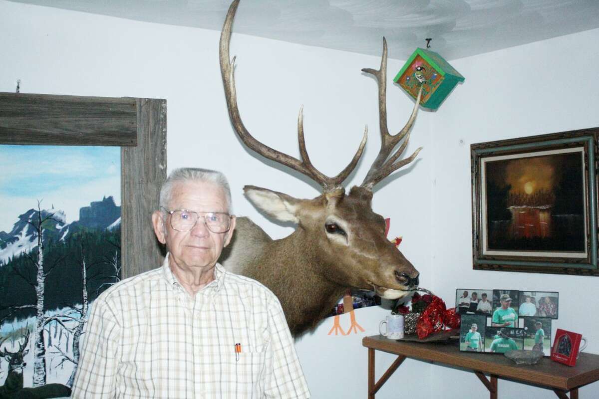 SHOWCASE: Bill Renshaw stands in his rural Evart home near one of his trophies from any years of hunting. (Herald Review photo/John Raffel)
