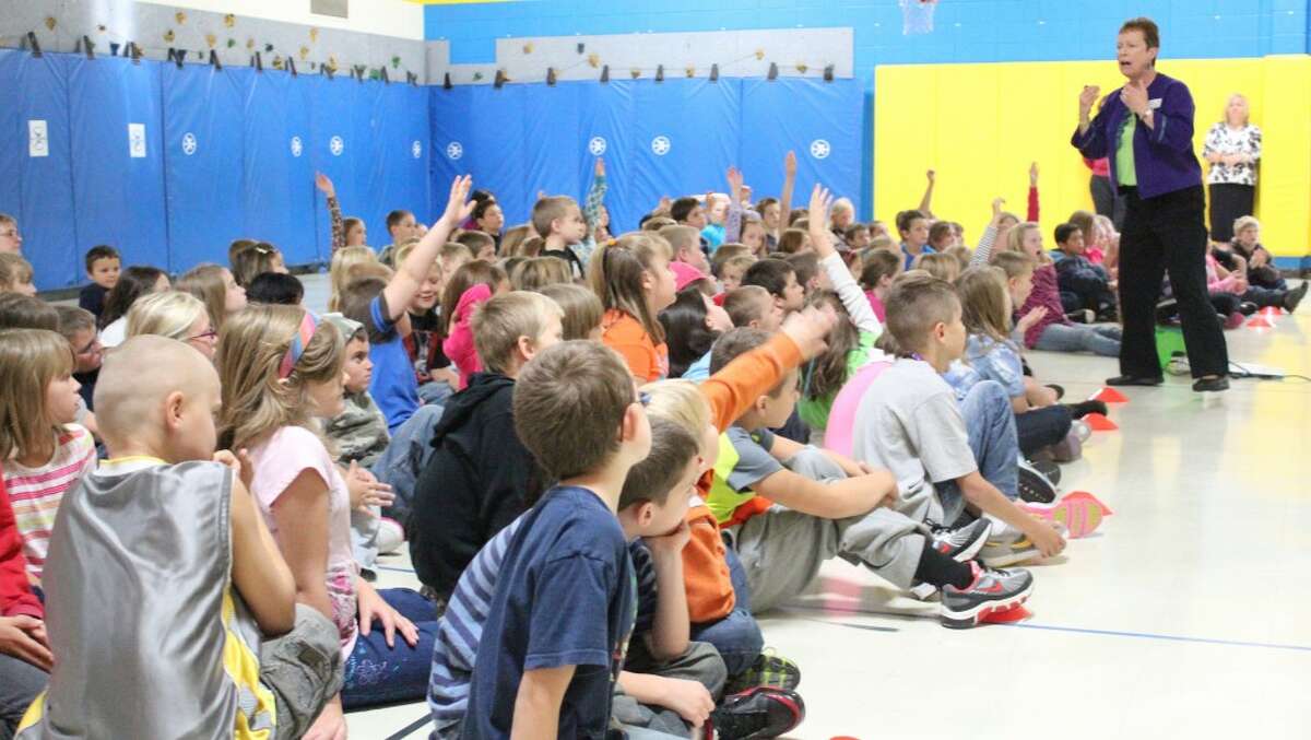 HANDS UP: Evart Elementary students raise their hands during an assembly in the school's gymnasium on Sept. 20. The school hosted the Bucket-Fillers, who taught students to fill the buckets of others by speaking positive words and being nice. (Herald Review photo/Sarah Neubecker)
