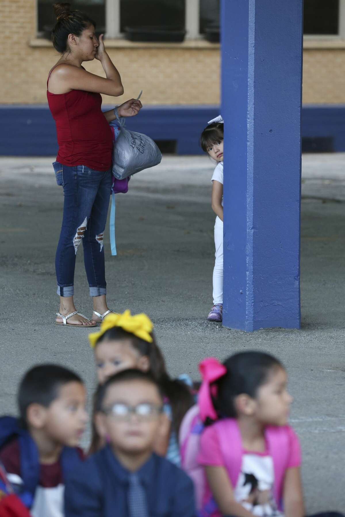 Lexie Elizondo, 4, refuses to join the rest of the pre-kinder students as her mother, Claudia Chavarria tries to coax her on the first day of classes at the newly reopened Athens Elementary School in the South San Independent School District, Monday, Aug. 19, 2019. Athens in one of three schools that were reopened in the district that also includes Kazen Middle School and West Campus. The district spent nearly $3 million in improvements at the schoolsl.