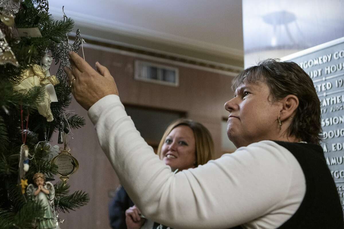 Conroe resident Sandy Trotter looks through angels hung on the Tree of Angels before the 22nd annual Montgomery County Tree of Angels Dedication on Tuesday, Dec. 11, 2018 at the Montgomery County Courthouse in Conroe.