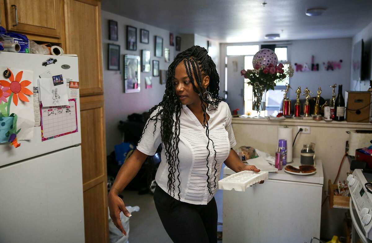 Shantel McClendon turns to put a filled ice cube tray in the freezer as she prepares breakfast the morning of her eviction hearing Thursday, July 11, 2019, in San Francisco, Calif. McClendon and her five children are facing eviction from their public housing in Mission Dolores. The last two years has been a series of notices for a variety of reasons and the most recent being that the father of her children has arguably spending too much time at her home. �I�m scared more than anything.� McClendon says. �I have five babies that depend on me- that�s what makes it hard.� McClendon has never had the threat of eviction before or gone through this process in the 14 years she�s lived in her home. She shared that she is most scared about losing her home �for nothing I even did- for wanting my kids� dad to be in their life. For nothing.�