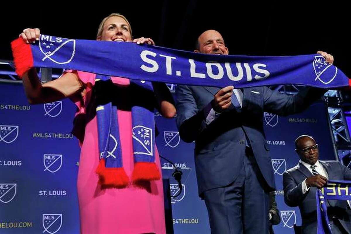 Carolyn Kindle Betz, a member of the ownership group of the new soccer franchise, and Major League Soccer Commissioner Don Garber display a St. Louis soccer scarf after the announcement, Tuesday, Aug. 20, 2019 in St. Louis. Major League Soccer has awarded the next expansion franchise to St. Louis, where a new downtown stadium will be built and the team will begin play during the 2022 season.